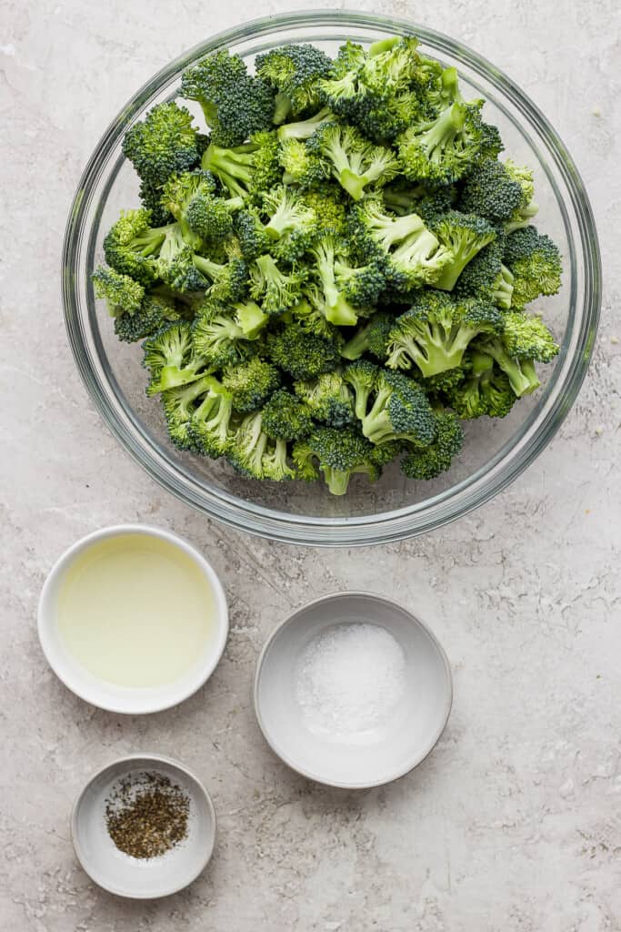a bowl of broccoli and two bowls of milk.
