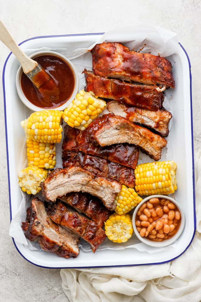 Grilled ribs on a serving tray with BBQ sauce.