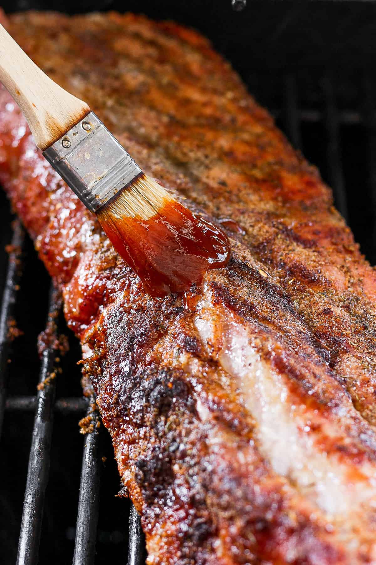 Rack of ribs brushed with BBQ sauce.