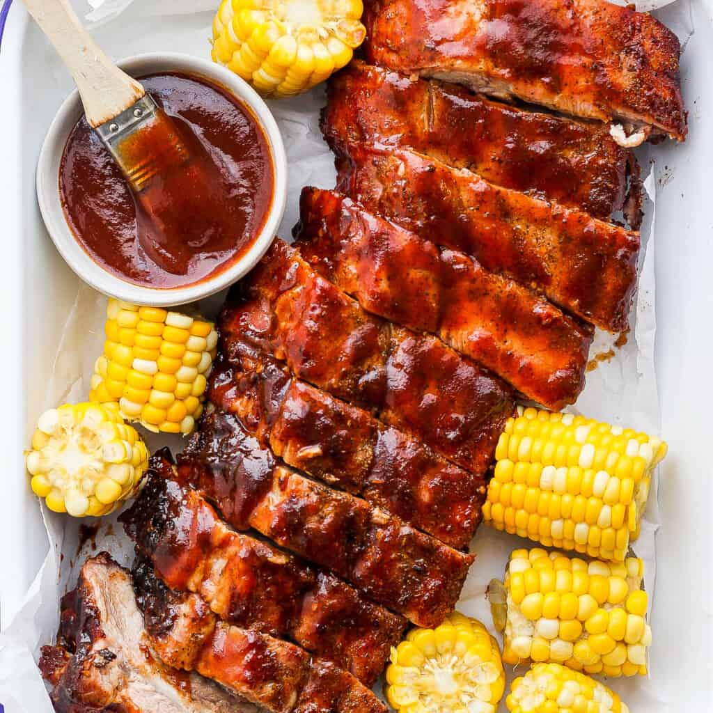Grilled ribs with maize  connected  the cob.