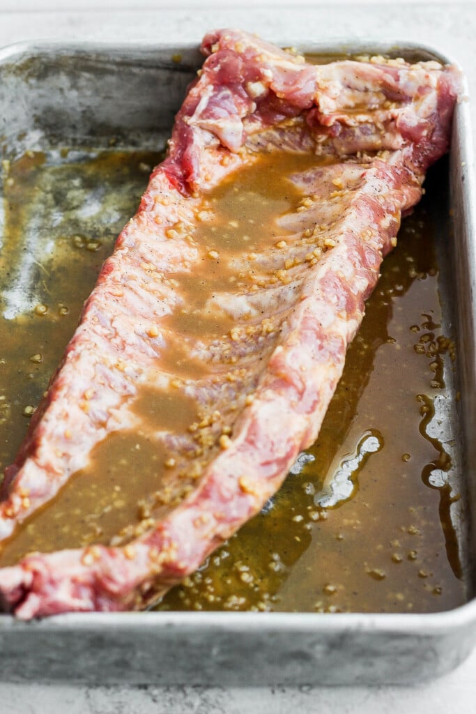 Rack of baby back ribs being marinated.