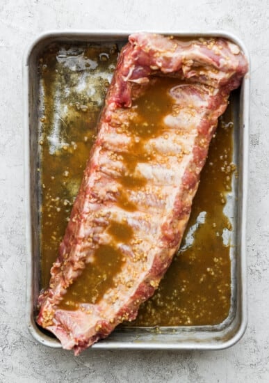 A rib in a pan with marinade.