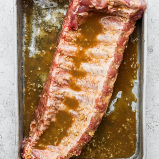 A rib in a pan with marinade.