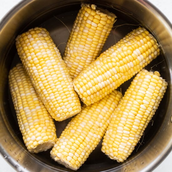 Corn on the cob in a metal bowl.