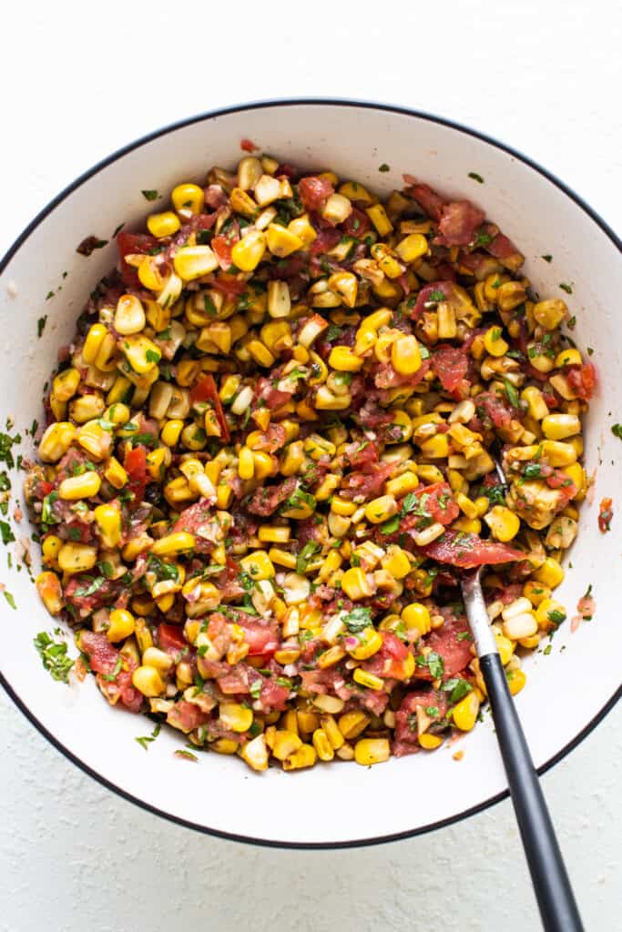 corn salsa in a white bowl with a fork.