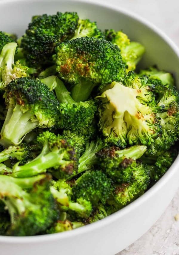 roasted broccoli in a white bowl.