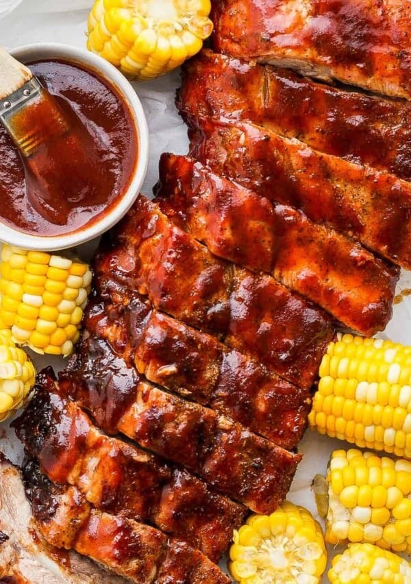 barbecue ribs and corn on the cob with bbq sauce.