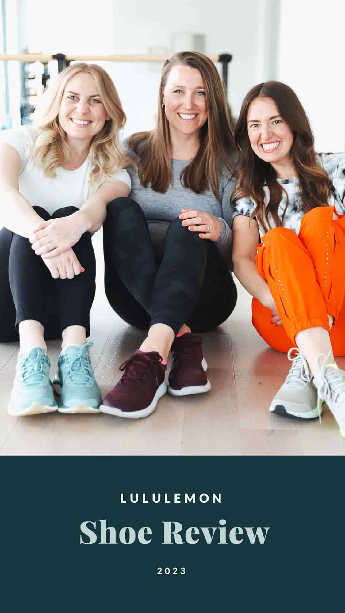 Three women sitting on the floor smiling.