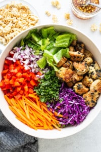 A white bowl filled with asian chicken salad.