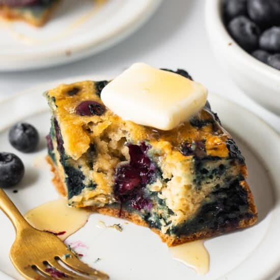 Blueberry pancakes on a plate with a fork.