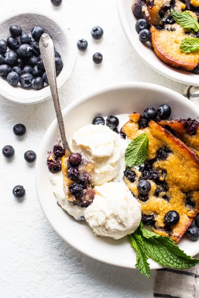 blueberry cobbler with ice cream in bowl.