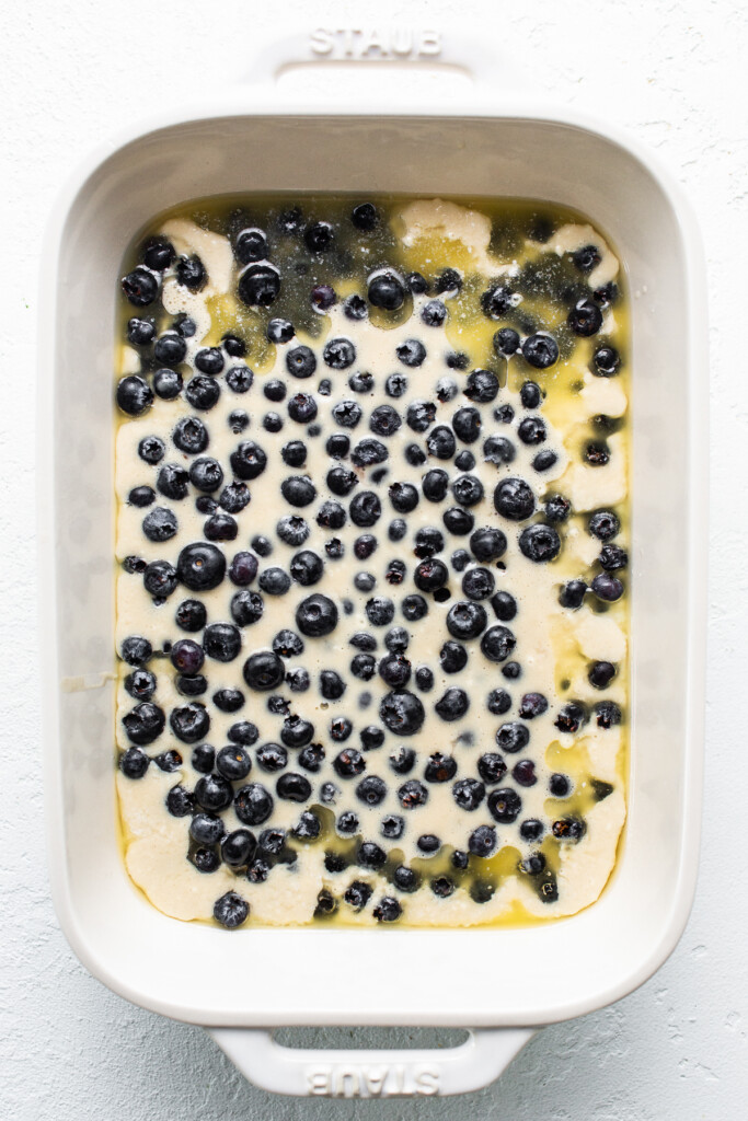 Uncooked blueberry cobbler in a casserole dish.