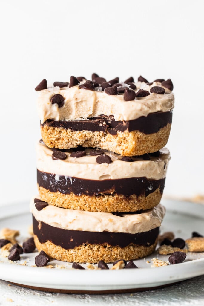 Peanut butter chocolate cheesecake cups stacked on a plate.