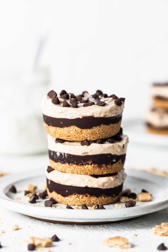 Peanut butter chocolate cheesecake cups stacked on a plate.