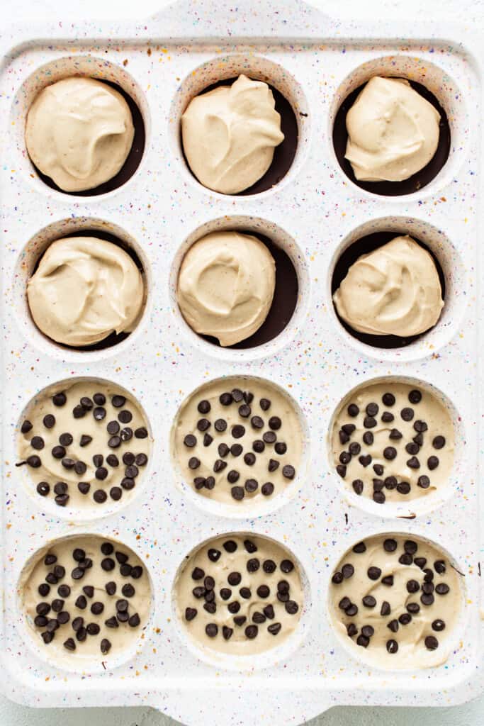 Peanut butter chocolate cheesecake cups in a muffin tin.