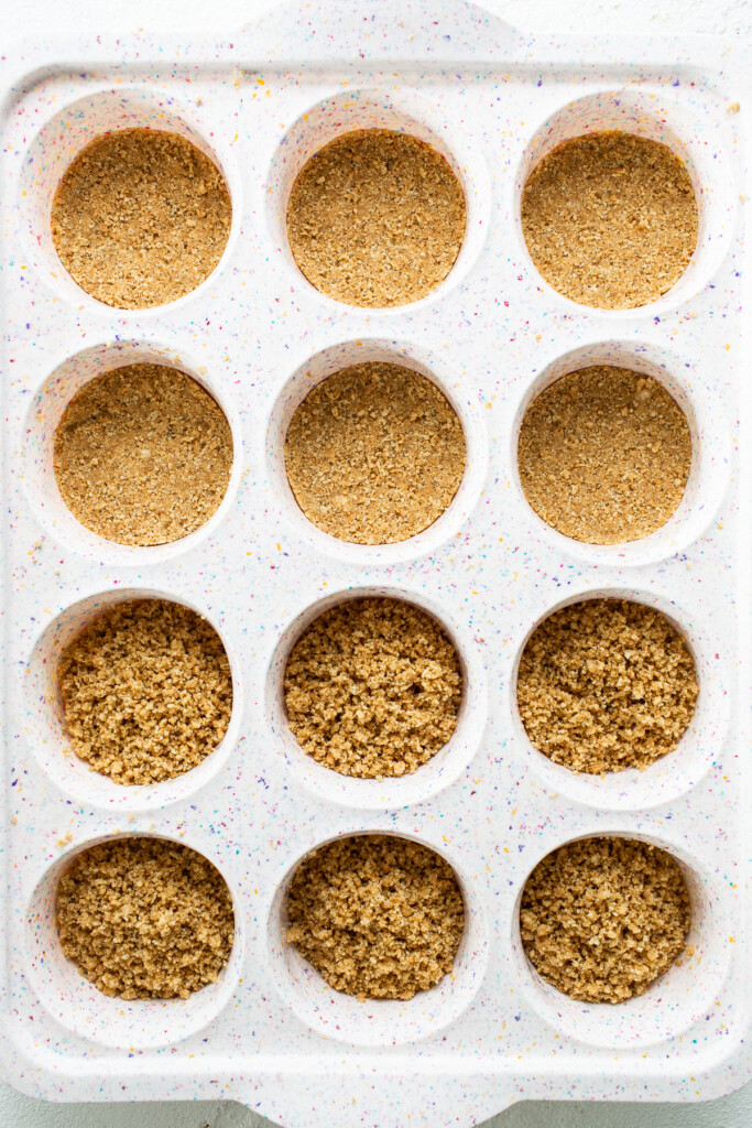 Graham cracker crust in a muffin tin.