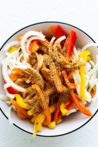 A bowl filled with peppers and onions.