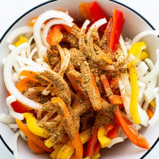 A bowl filled with peppers and onions.