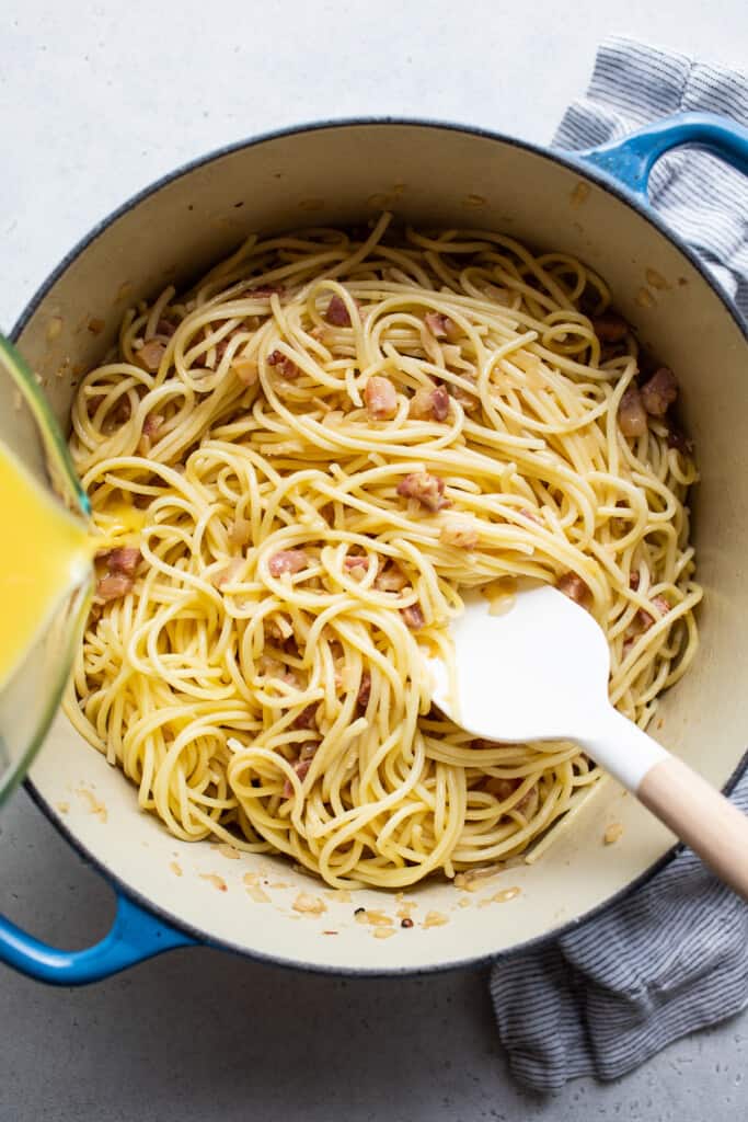 A pot of spaghetti with bacon and orange juice.