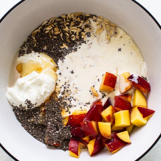 A bowl with yogurt, peaches and chia seeds.