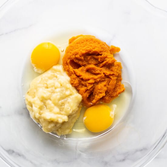 Two eggs and mashed sweet potato in a bowl.