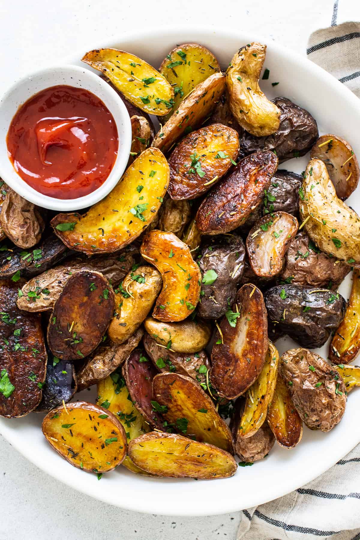 bowl of roasted potatoes and ketchup.