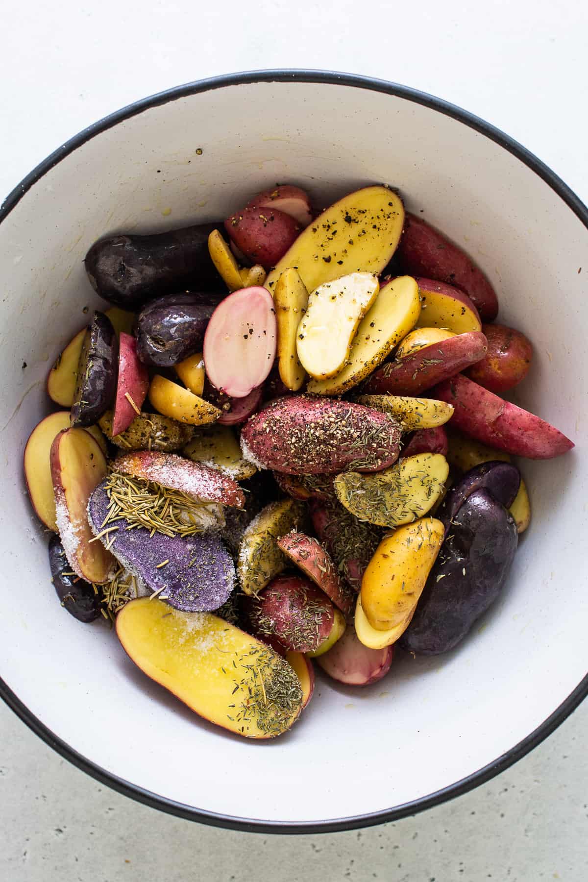 seasoning potatoes in bowl.