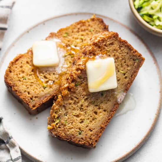 two slices of bread with butter on a plate.