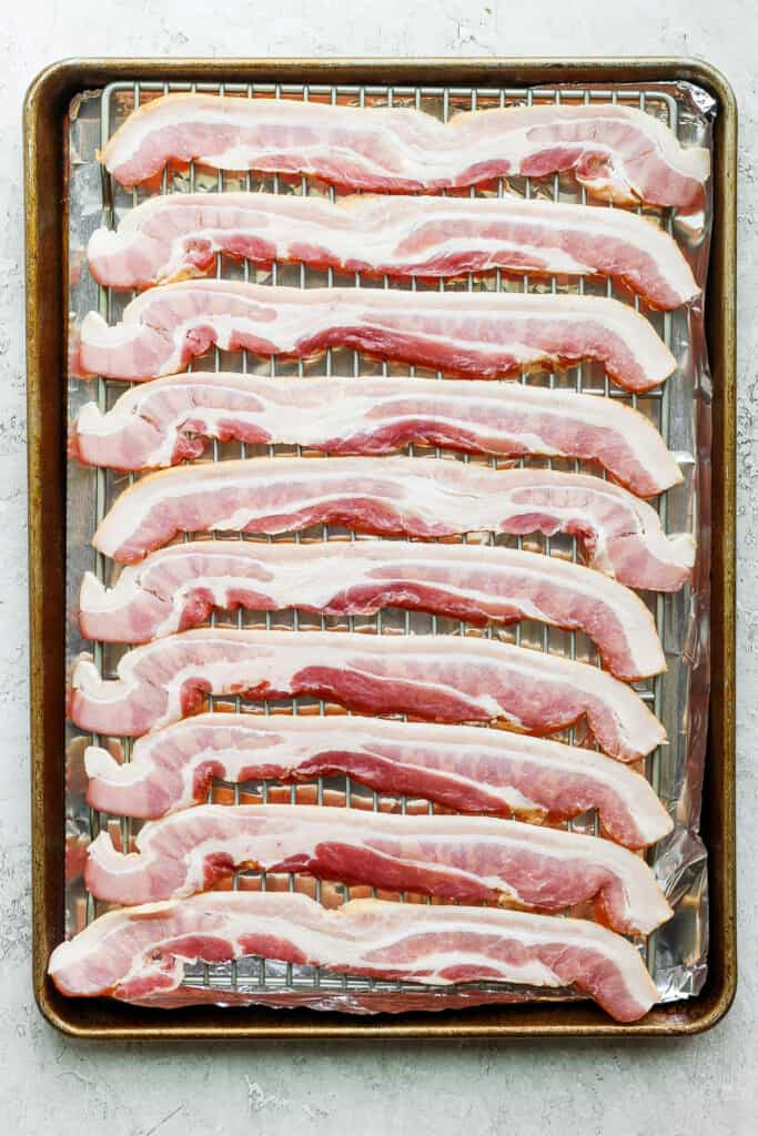 sliced bacon on a baking sheet.