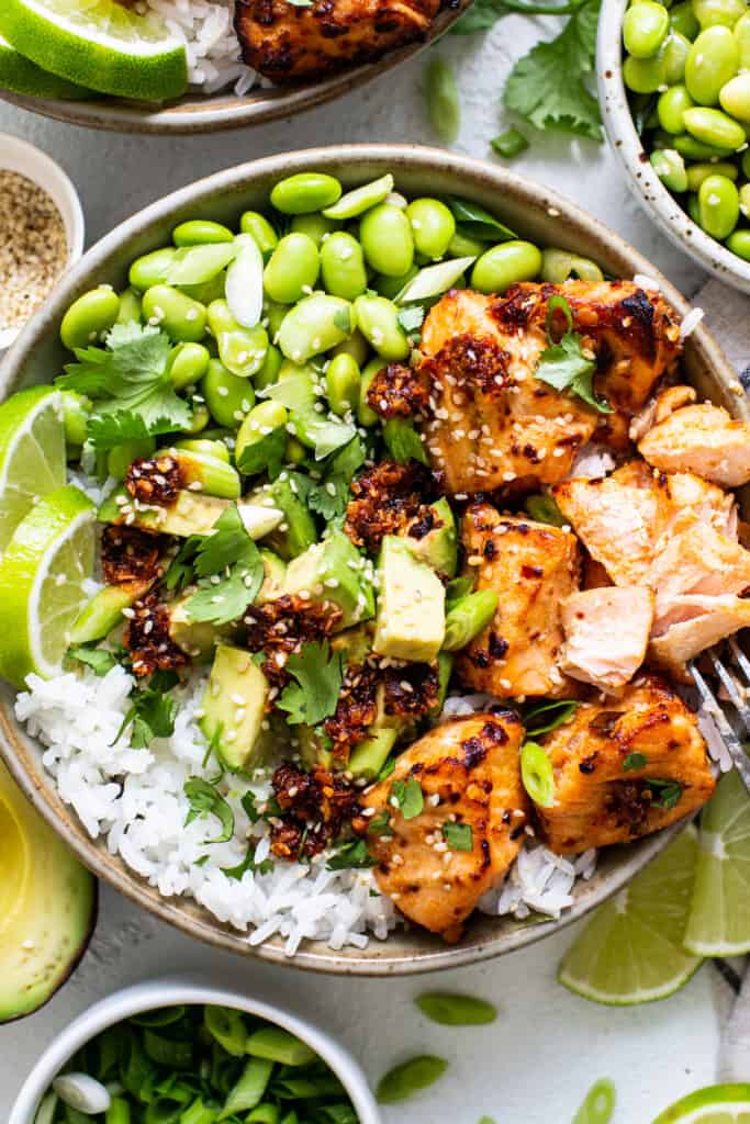 a bowl of chicken, rice, peas, and limes.