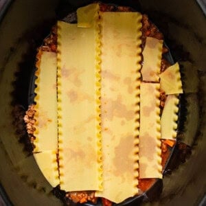 a crock pot filled with pasta and sauce.