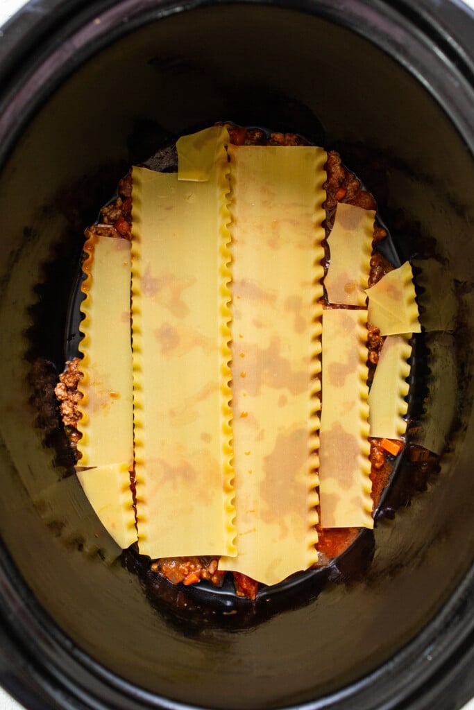 a crock ، filled with pasta and sauce.