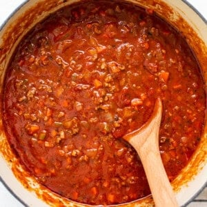 a pot of chili with a wooden spoon in it.