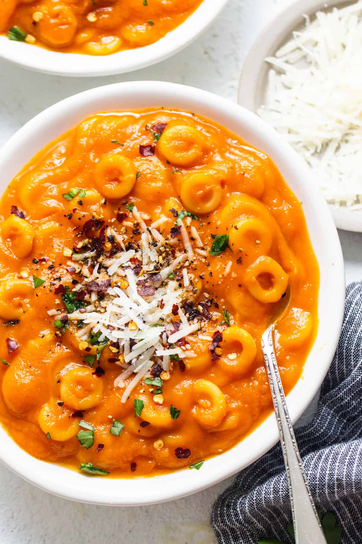 two bowls filled with pasta and cheese on top of a table.