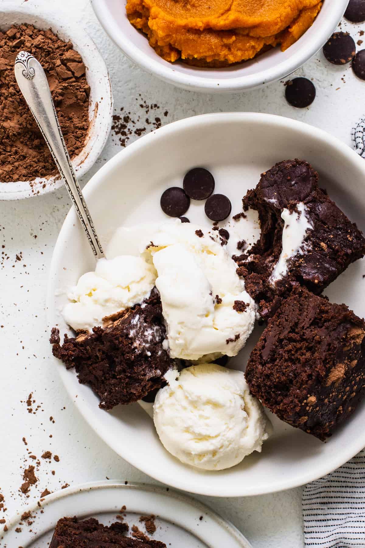 a white bowl filled with brownies and ice cream.