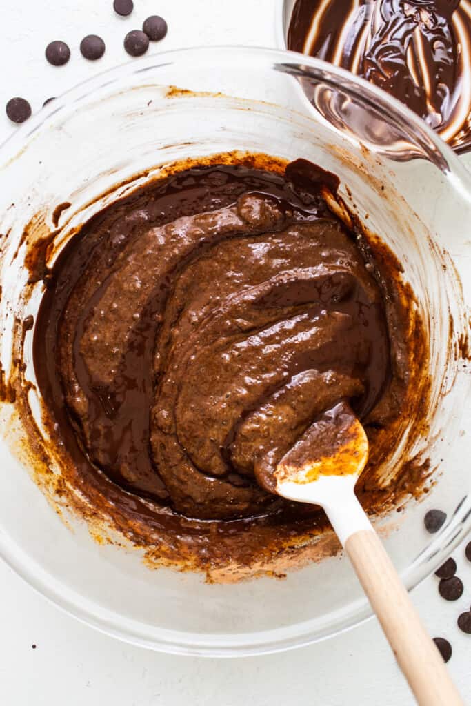 a bowl of chocolate pudding with a wooden spoon.