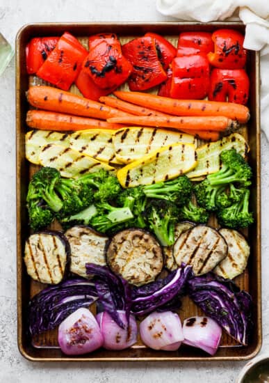 a tray of grilled vegetables including carrots, broccoli, red onions.