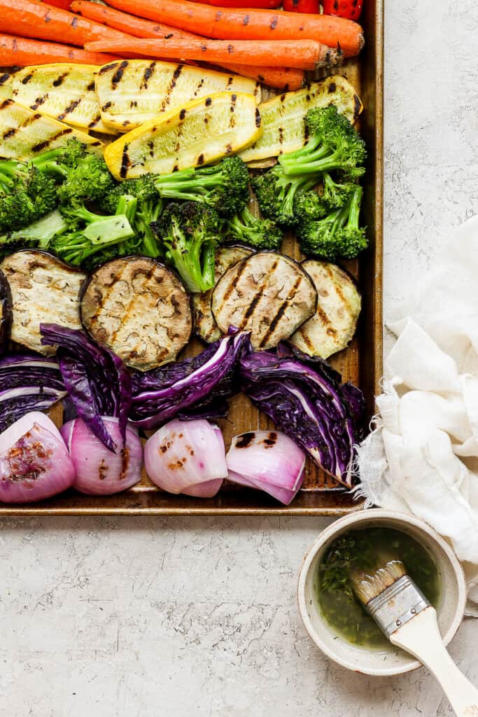 a tray of grilled vegetables and a bowl of soup.