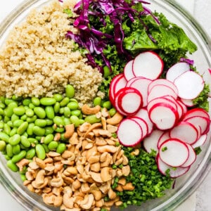 a bowl filled with greens, radishes and quinoa.