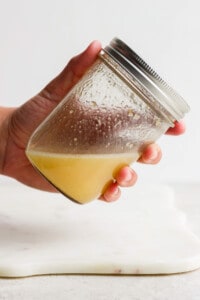 a person holding a jar of lemon juice.