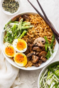 a bowl of asian noodles with an egg and mushrooms.