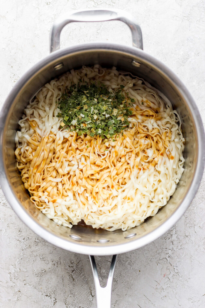 a pan with rice and herbs in it.