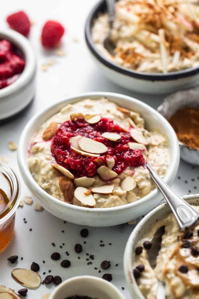 a bowl of oatmeal with raspberries and almonds.