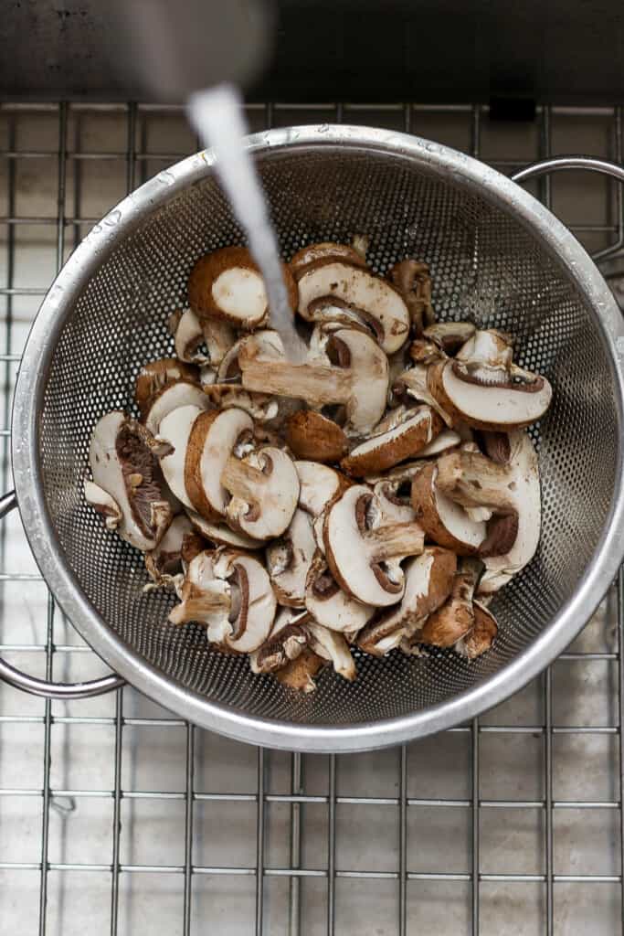 mushrooms in a strainer on a cooling rack.