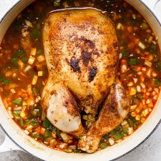 a chicken in a pot of soup.