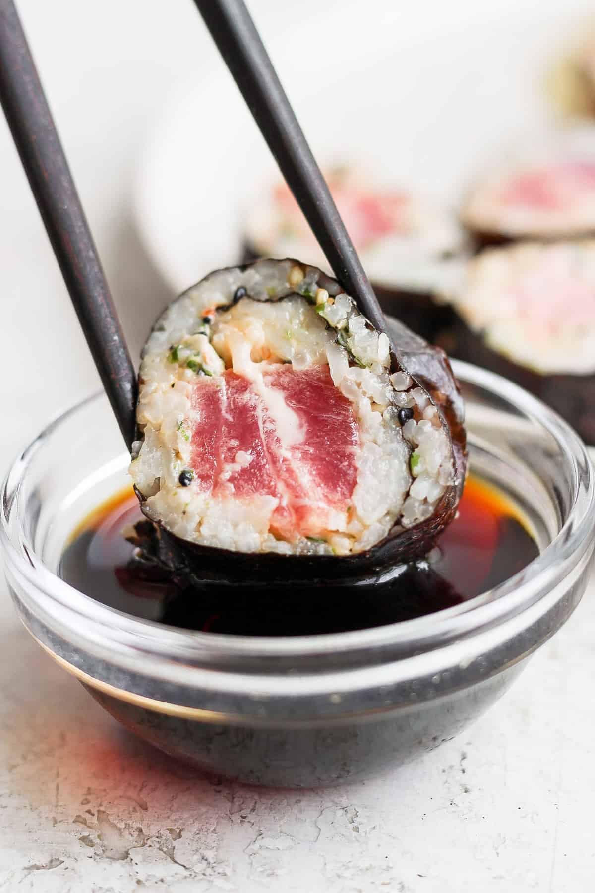 japanese tuna sushi in a bowl with chopsticks.