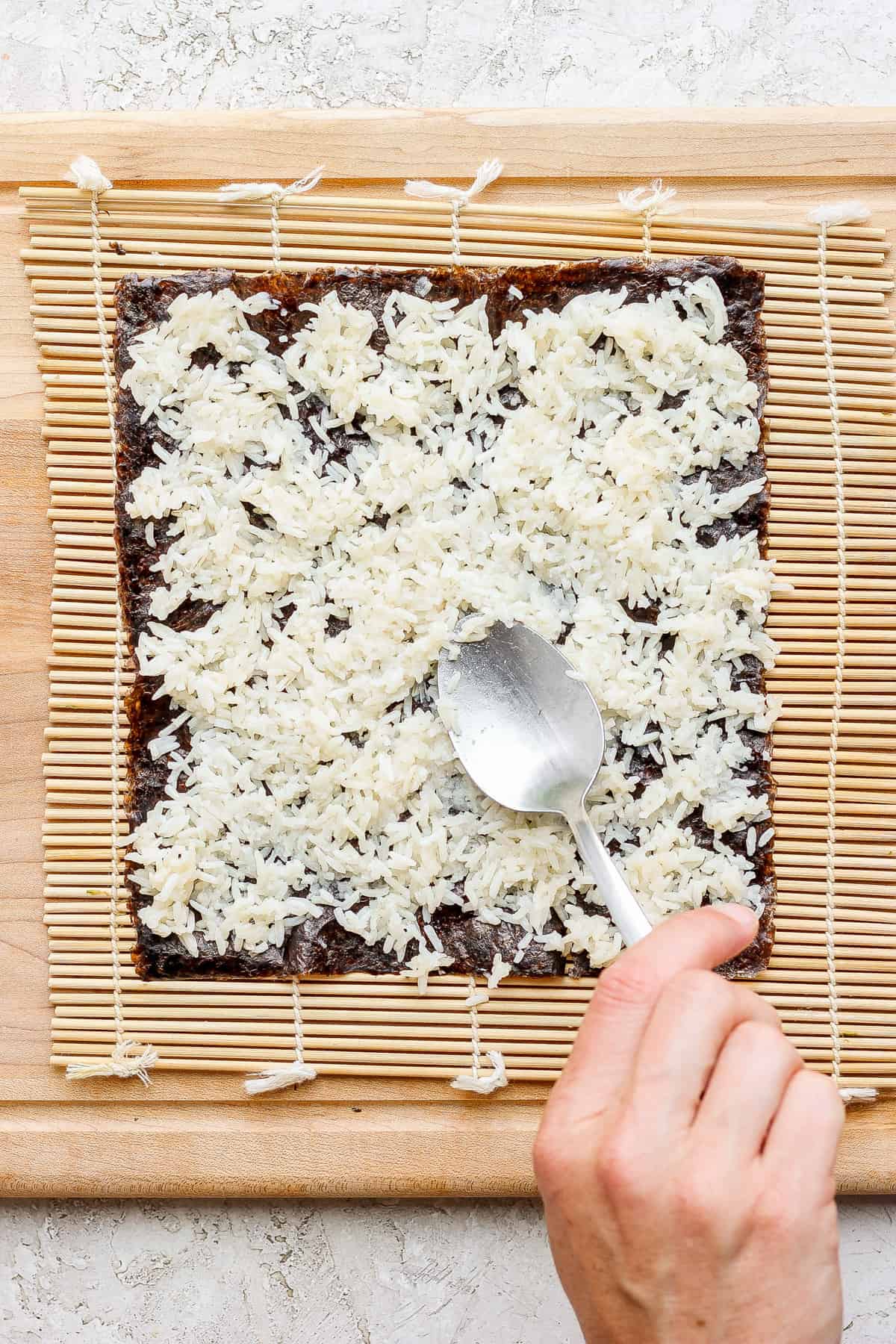 a person slicing a square of chocolate on a cutting board.