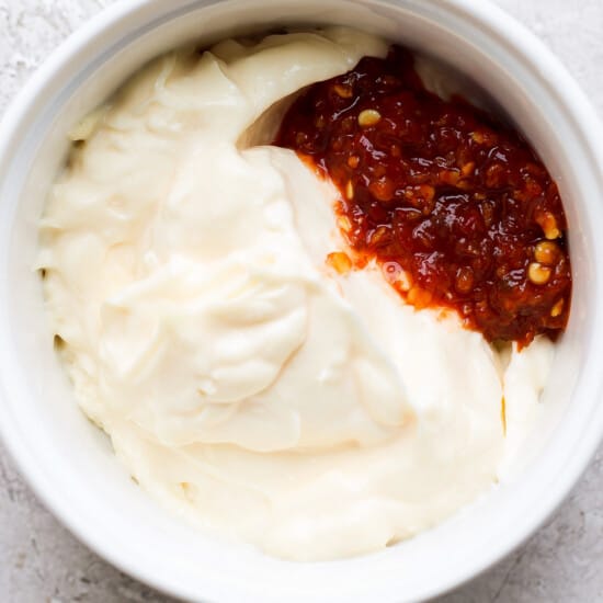 a bowl of whipped cream with a red sauce.