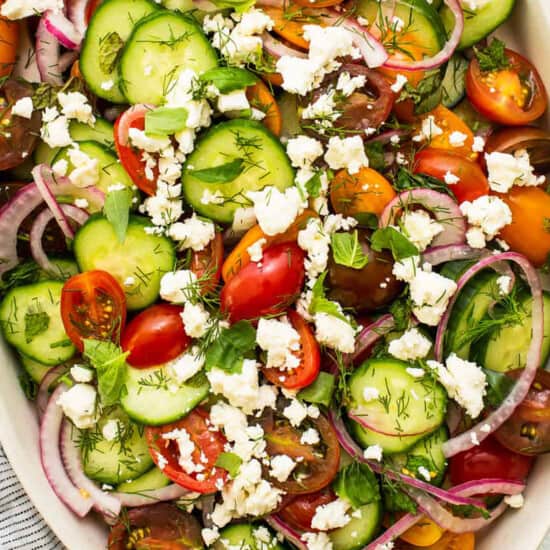 a refreshing cucumber tomato salad topped with feta cheese.