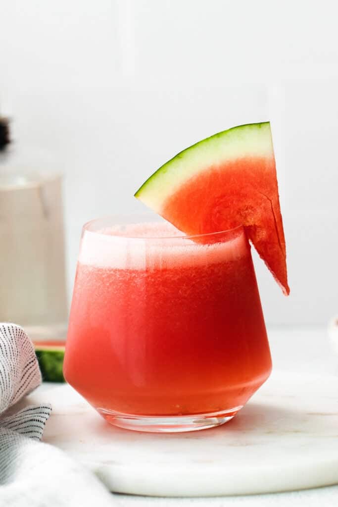 a watermelon drink in a glass with a slice of watermelon on.